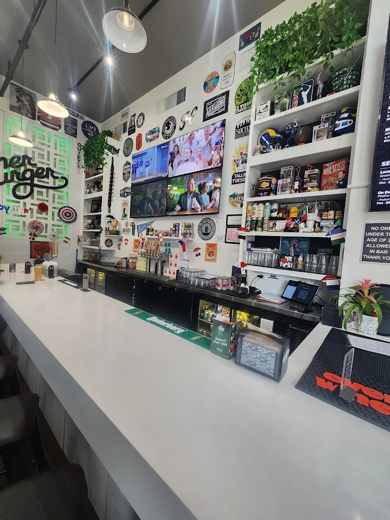Hammer Burger bar with draft taps, sticker-covered walls, and memorabilia